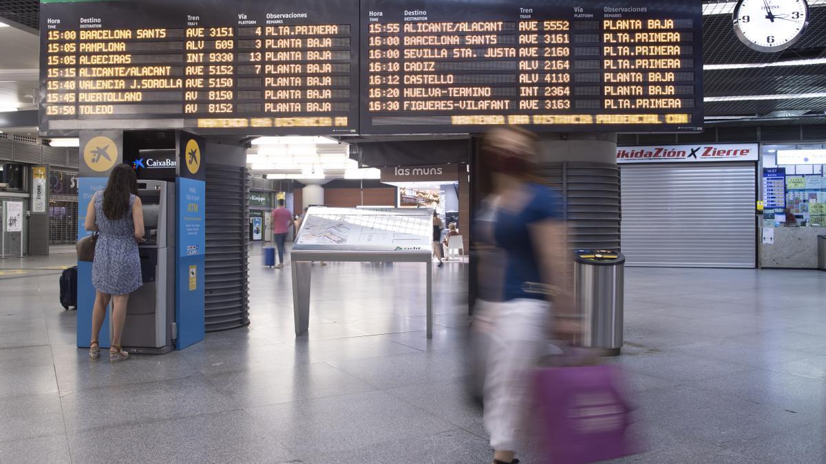 Pasajeros en el panel de salidas de la estación de AVE de Atocha.