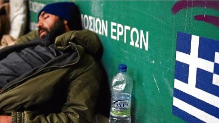 Un home dorm en una entrada del metro d&#039;Atenes.