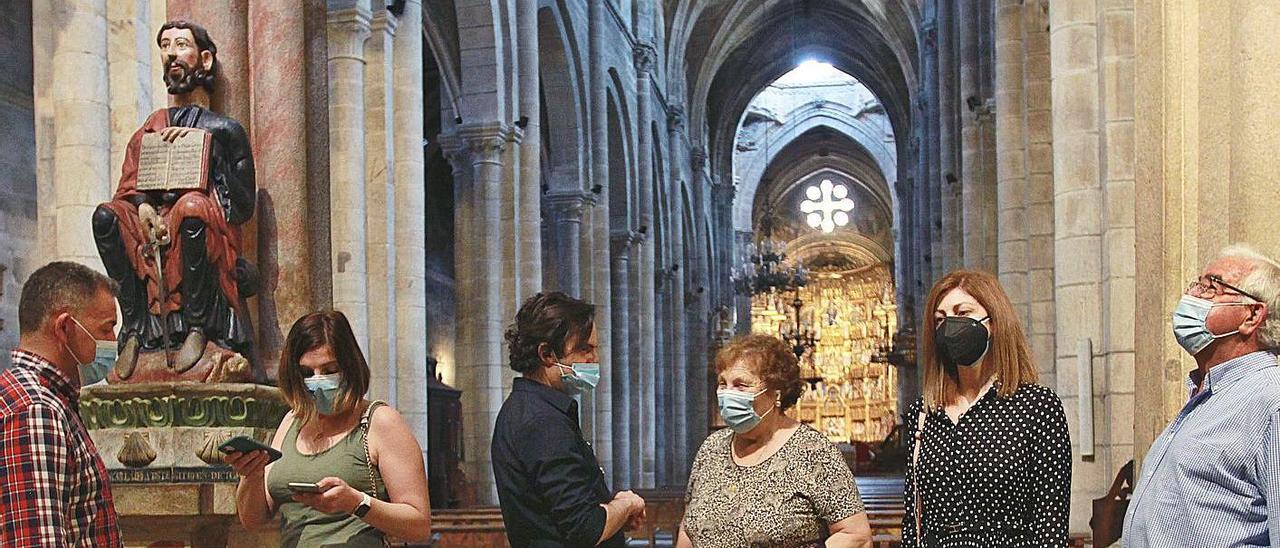 Un grupo de turistas, con mascarillas, conociendo los secretos de la catedral de Ourense. |   // IÑAKI OSORIO