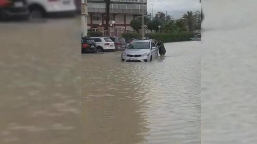 La lluvia deja aparcamientos de la playa de San Juan inundados y los coches bloqueados