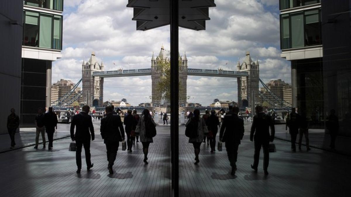 Trabajadores de la City pasan junto a la Torre de Londres.