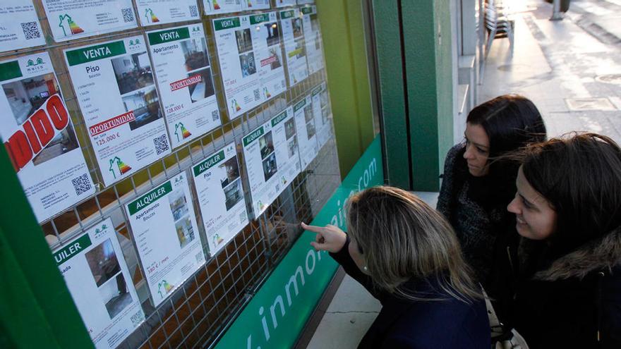 Un grupo de mujeres consulta los anuncios de una inmobiliaria en Vigo // J. Lores