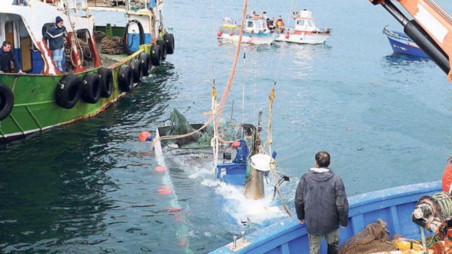 Las grúas del &quot;Portela Siete&quot; y &quot;Rivas Mar&quot; izan el &quot;Nuevo Vencedor&quot;, hundido junto al muelle en la dársena de Cangas.  // Gonzalo Núñez