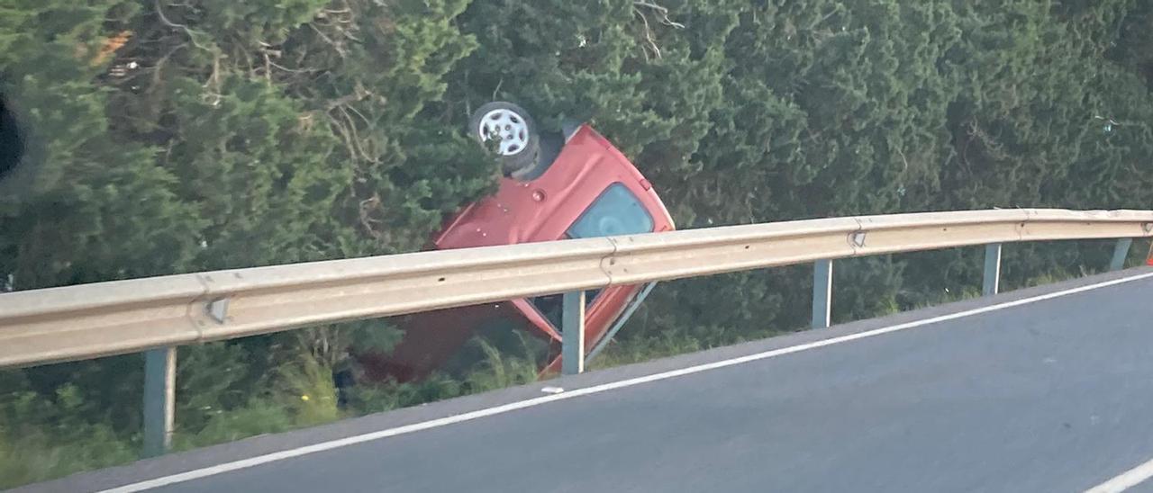 La furgoneta ha acabado volcada entre los árboles del lateral de la carretera.