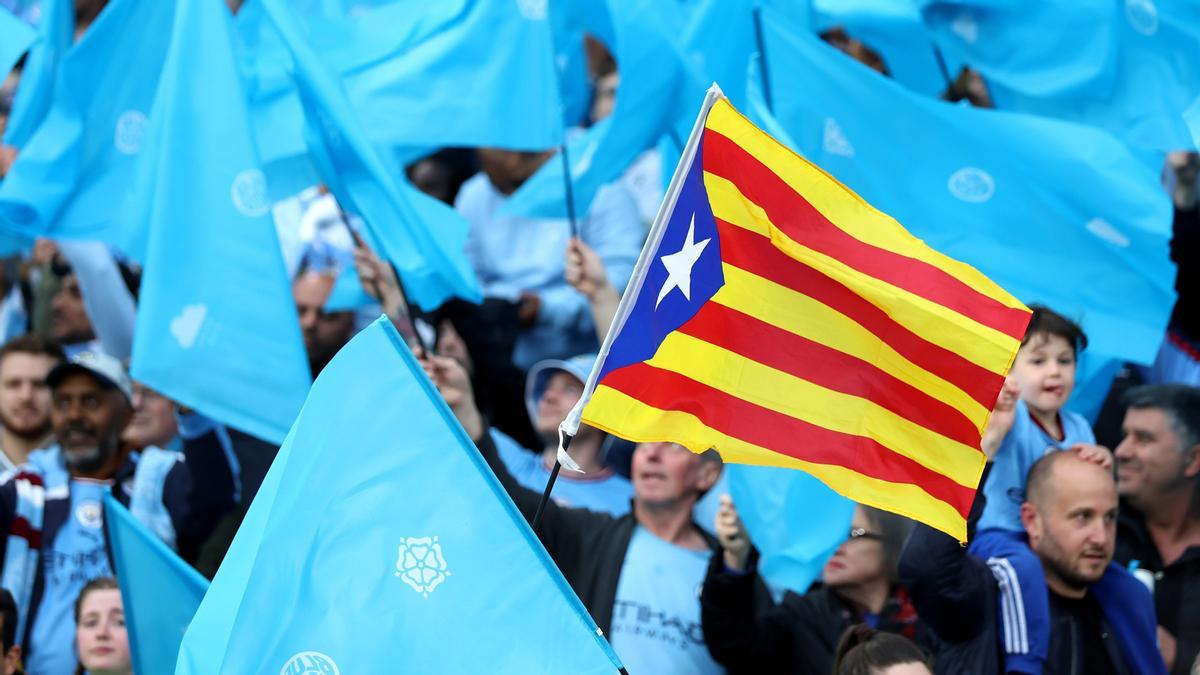 Una 'estelada', la bandera independentista catalana, en medio de banderas con los colores del Manchester City, en el partido que este miércoles enfrentó al Real Madrid con el Manchester City en Madrid.