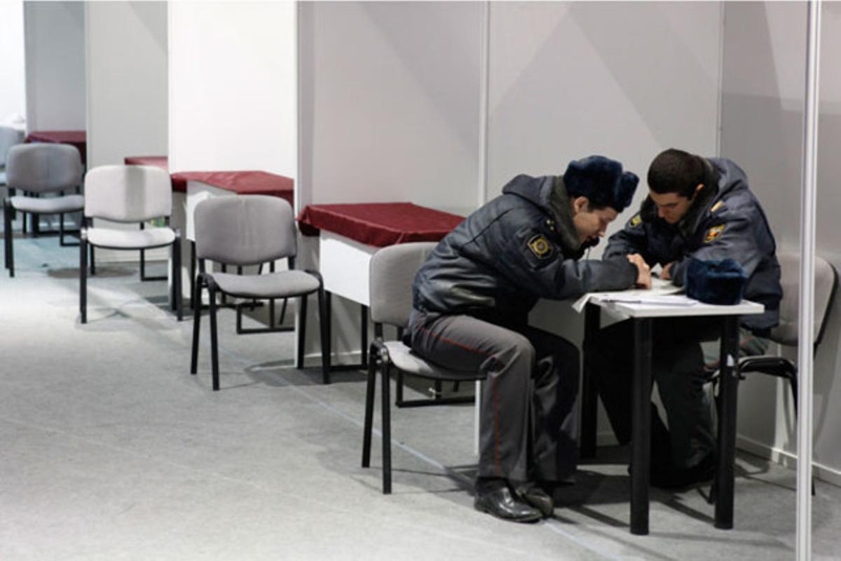 Oficials de la policia russa consulten les ofertes d’ocupació en un diari abans de la inauguració de la fira del treball a Stavropol (Rússia).