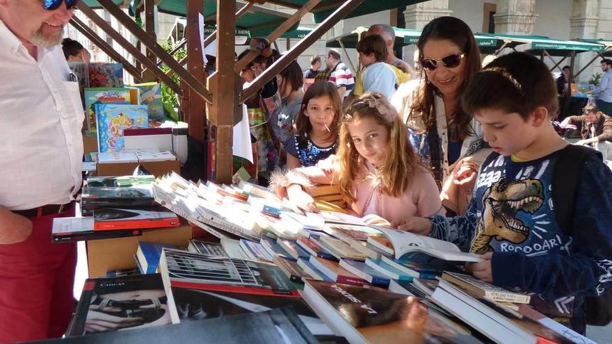 Manuel Laruelo elige un libro de animales, con su hermana Ana y su madre, Ana Cuesta, en el puesto de José Luis Carnota.