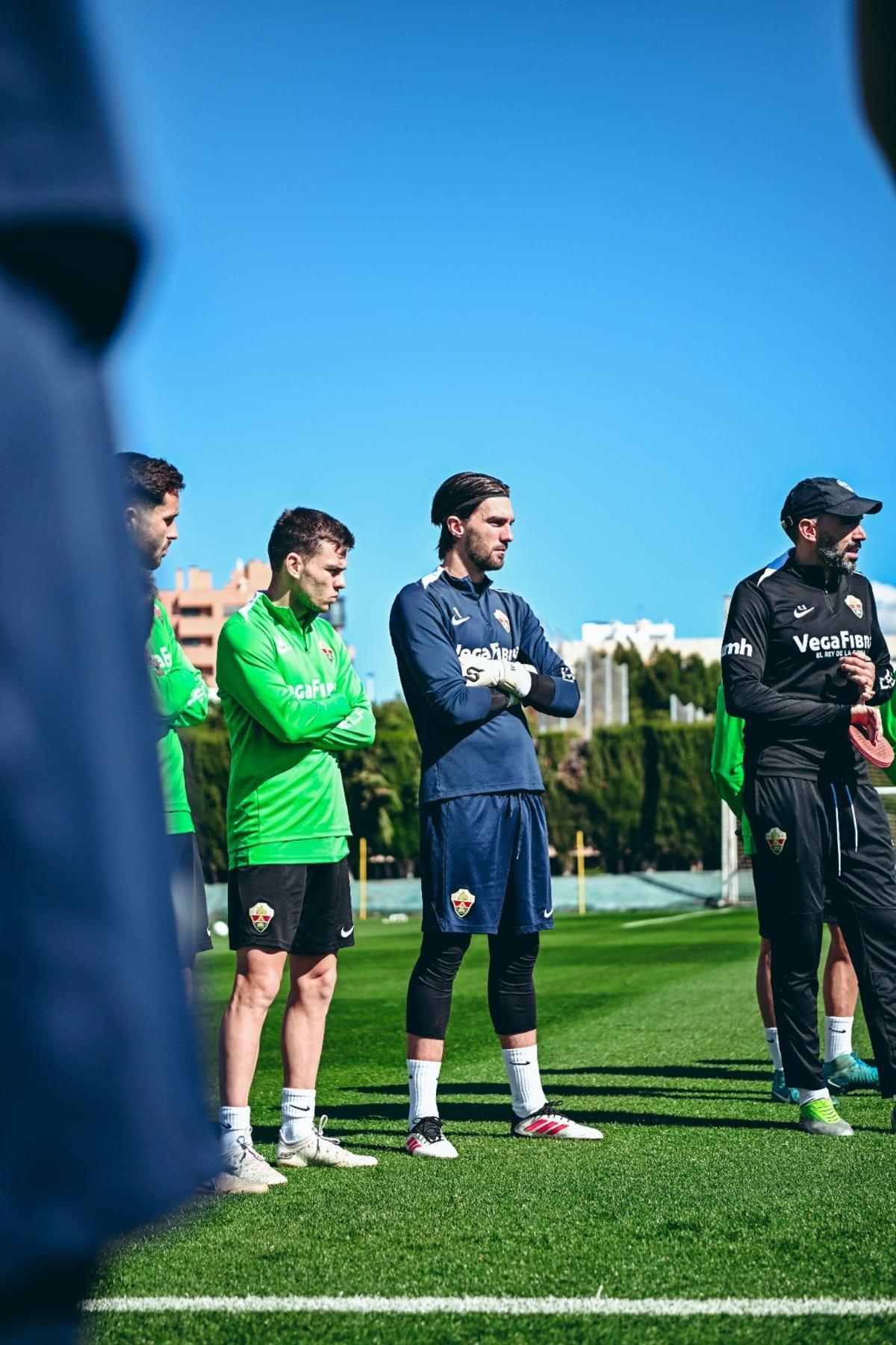 La plantilla del Elche atiende a Sarabia durante una charla previa a un entrenamiento, en el Díez Iborra.