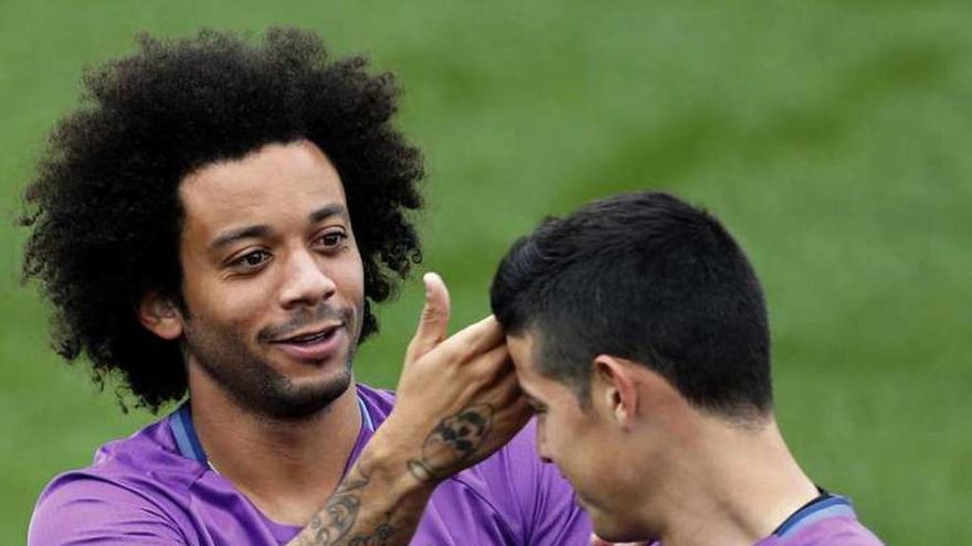 Marcelo y James bromean durante el entrenamiento. // Efe