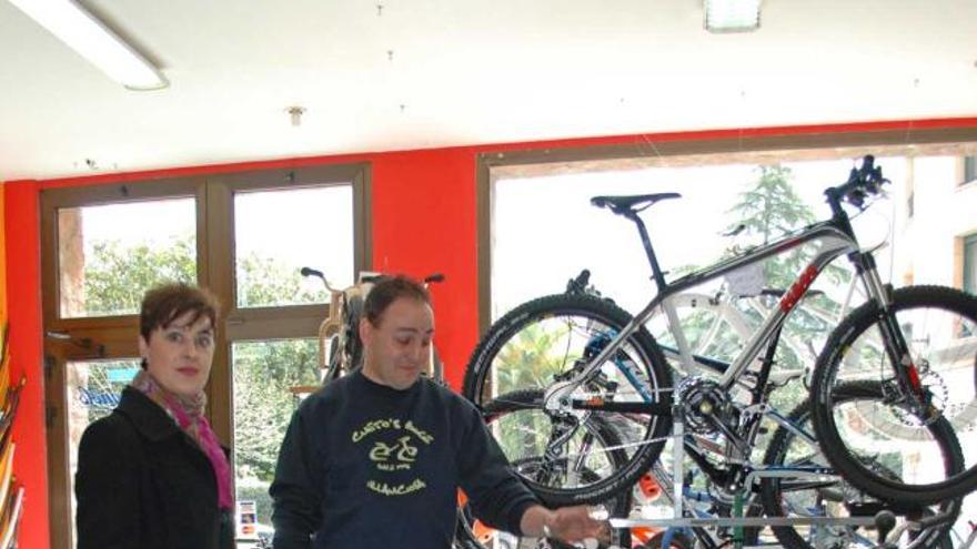 Silvia Elena García asesora a Juan Cueto en su tienda de bicicletas.