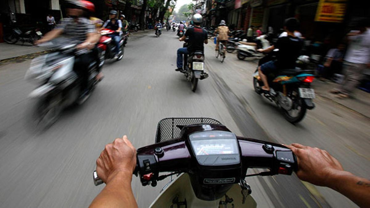 Un motociclista intenta esquivar el trànsit de Hanoi. El Govern vietnamita ha promulgat un reglament per ordenar el vertiginós trànsit de la capital.