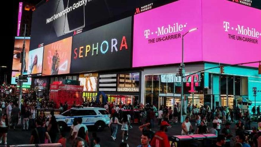 Neoyorkinos deambulando por Times Square, cuyos rótulos publicitarios sí funcionaron durante el apagón. // Reuters