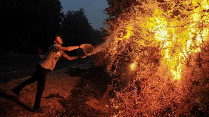 Vecinos de Pereiro de Aguiar (Ourense) sofocan un incendio cerca de sus casas.