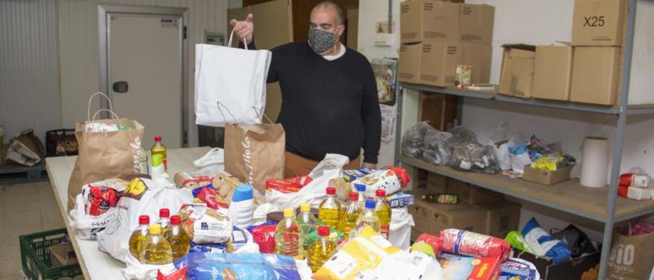 José García, ayer, con los alimentos reunidos para O Mencer en el local de la asociación. |   // BERNABÉ/ANA AGRA