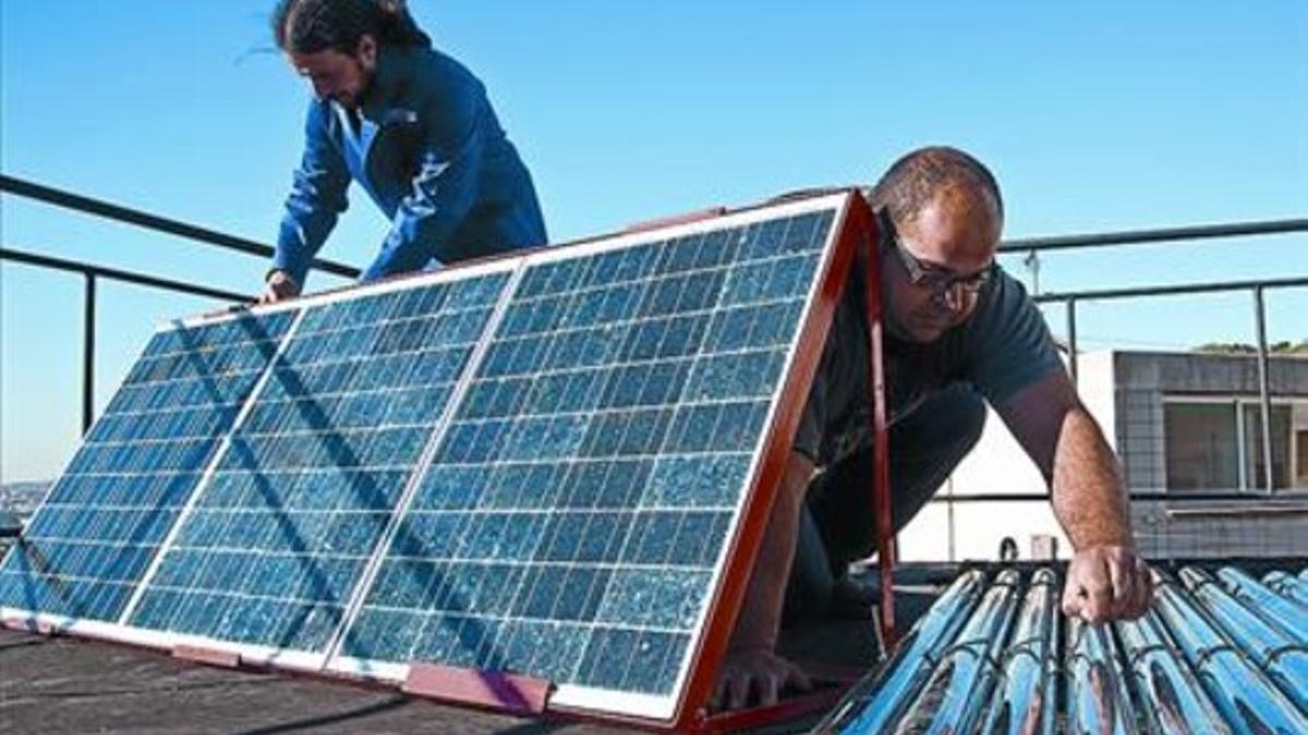 Dos alumnos de un curso de formación de parados de instalación de placas fotovoltaicas.