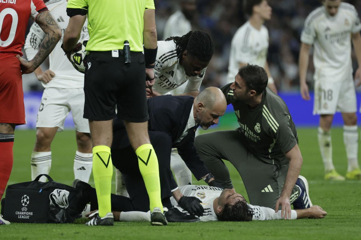 El defensa del Real Madrid Raúl Asencio (en el suelo) es atendido durante el partido de vuelta de la fase de acceso a los octavos de la Liga de Campeones que Real Madrid y Benfica disputaron en el estadio Santiago Bernabéu. EFE/Juanjo Martín. (REAL MADRID)