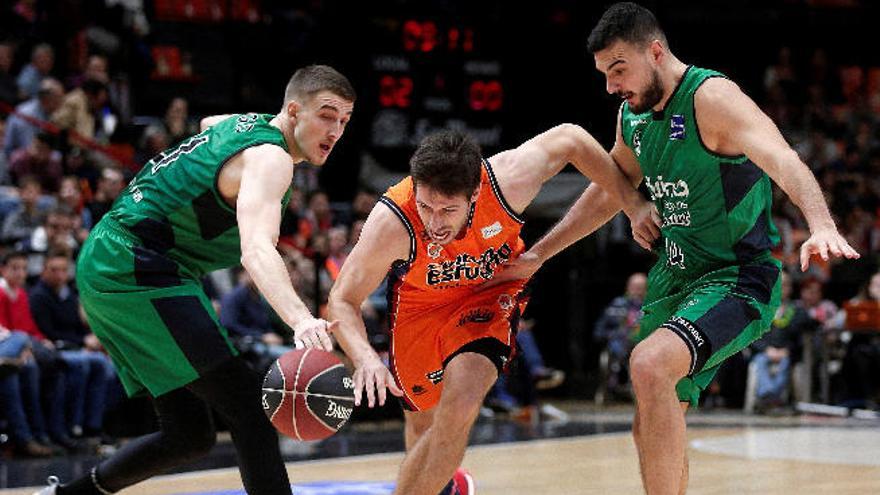 Van Rossom (Valencia) avanza ante dos rivales del Joventut.