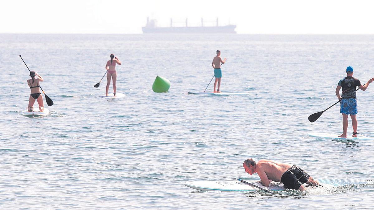 Personas practicando paddle surf en el Grao.