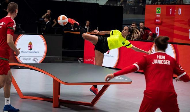 Natalia Guitler (C) de Brasil devuelve el balón a Csaba Banyik (L) y Zsanett Janicsek (R) durante el 3er Campeonato Mundial de Teqball final de dobles entre Hungría y Brasil en el Vasas Sports Hall en Budapest, Hungría.