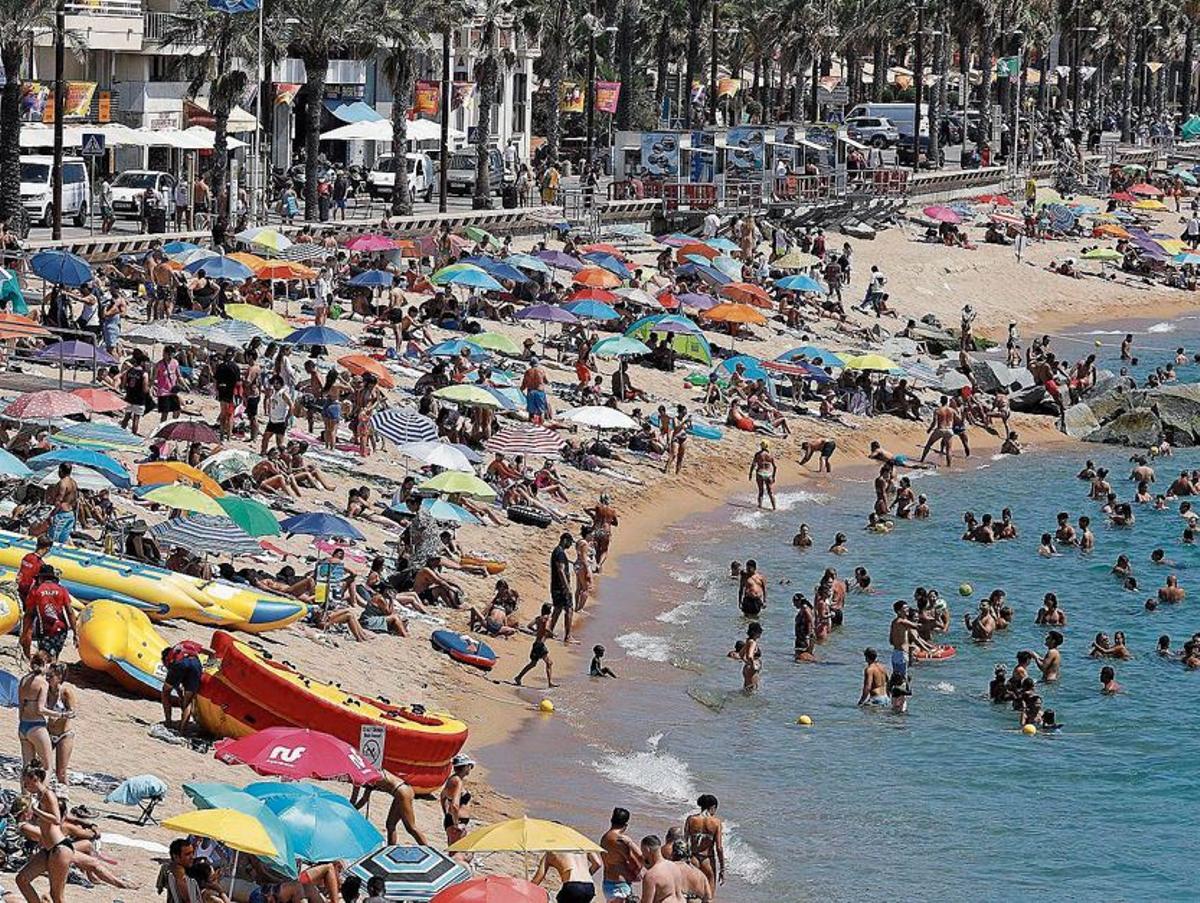 Una platja de la Costa Brava plena de banyistes, en una imatge d’arxiu.