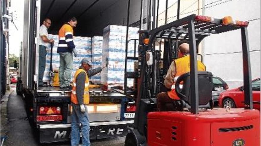 Personal del Banc dels Aliments de Girona descarregava ahir els 12.000 litres de llet donats per Mercadona.