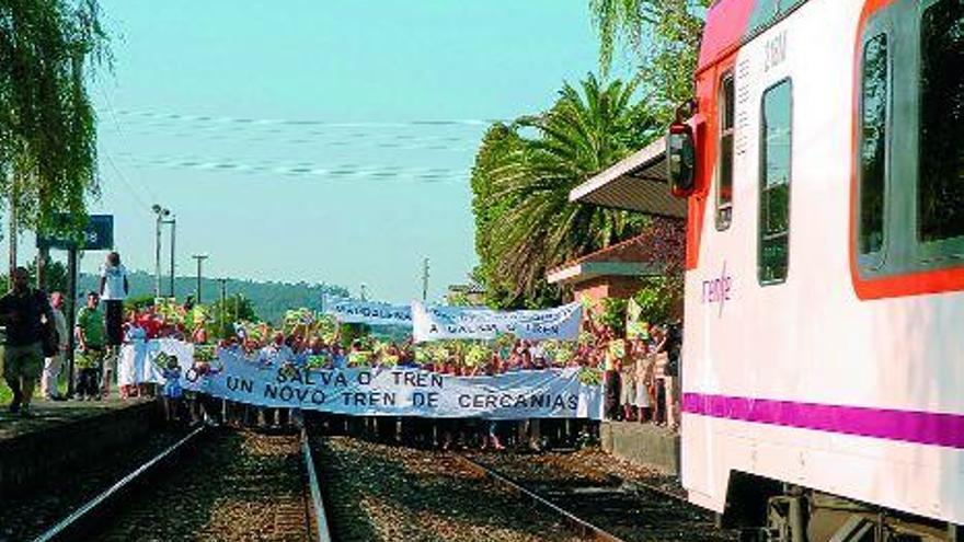 El tren se acerca a la estación de Portas lentamente, con los vecinos cortando la línea férrea a sólo unos metros de distancia. / Gustavo santos