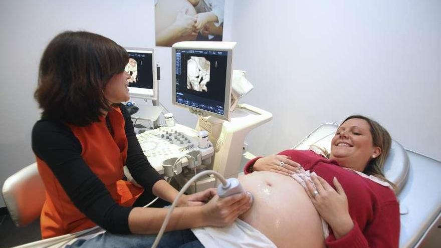 Una ginecóloga realiza una ecografía a una embarazada. // Efe