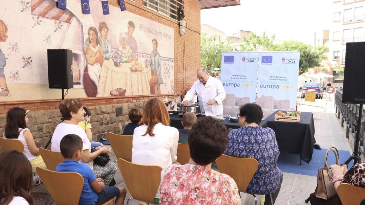 Vecinos y visitantes asisten a la preparación de una receta del chef Miguel Barrera.