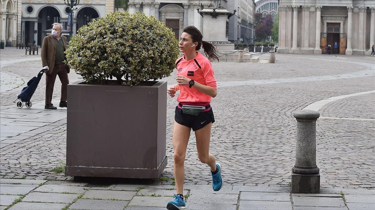 zentauroepp53169888 turin  italy   19 04 2020   a woman jogs in an empty street 200420183937