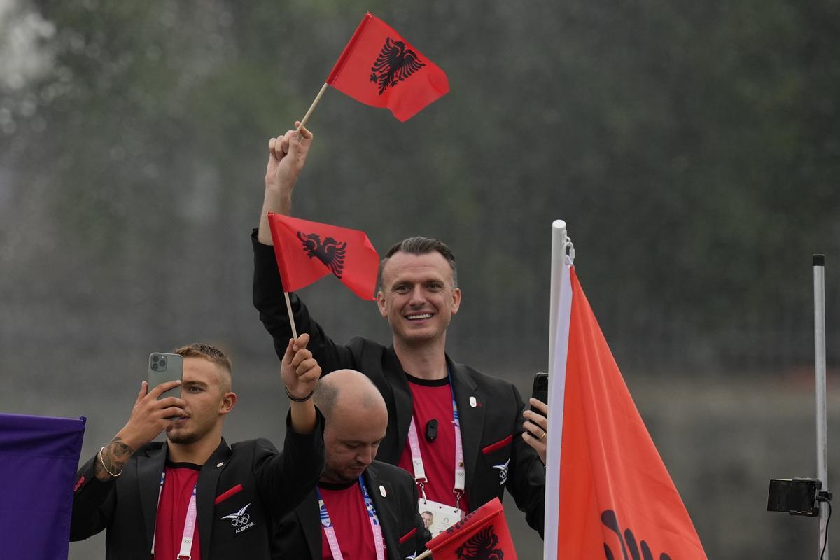 Miembros del equipo de Albania ondean banderas en París, Francia, durante la ceremonia de inauguración de los Juegos Olímpicos 
