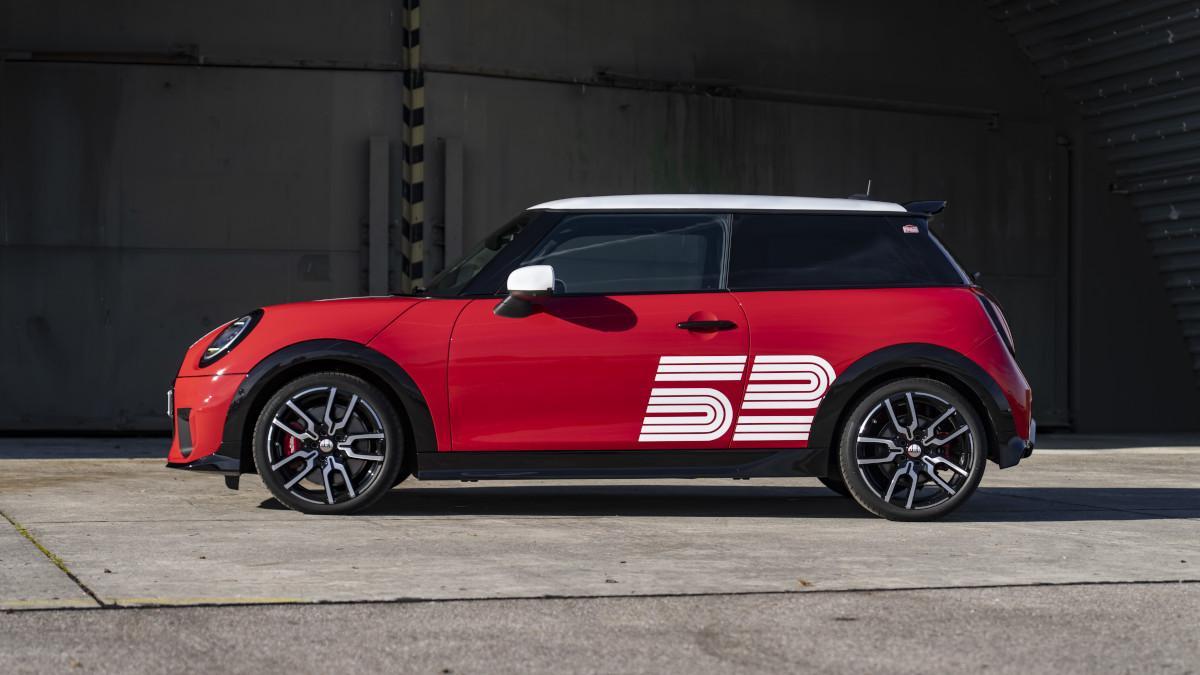 Visto de perfil resalta la carrocería Chili Red y el gráfico blanco con el dorsal 52, guiño directo al coche vencedor de 1965.