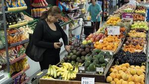 Clientela en una frutería del barrio del Carmel de Barcelona.