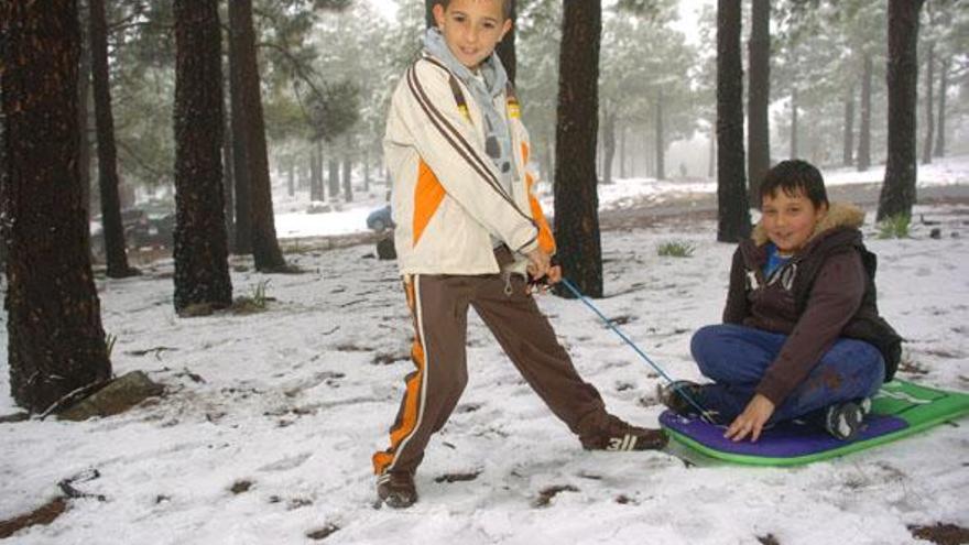 Los niños Yeribai y Giovanni juegan en la nieve en las inmediaciones de Los Pechos. i JUAN CARLOS CASTRO