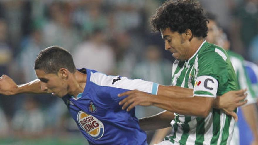 El centrocampista francés del Getafe CF, Abdelaziz Barrada (i), intenta controlar el balón ante el jugador brasileño del Real Betis, Iriney Santos Da Silva.
