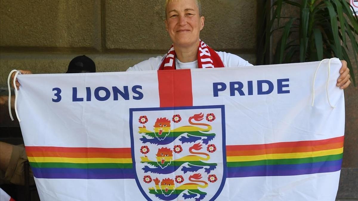 Din Cunningham sostiene una bandera inglesa, coloreada con el arco iris, el símbolo de la comunidad LGTB, en Volvogrado