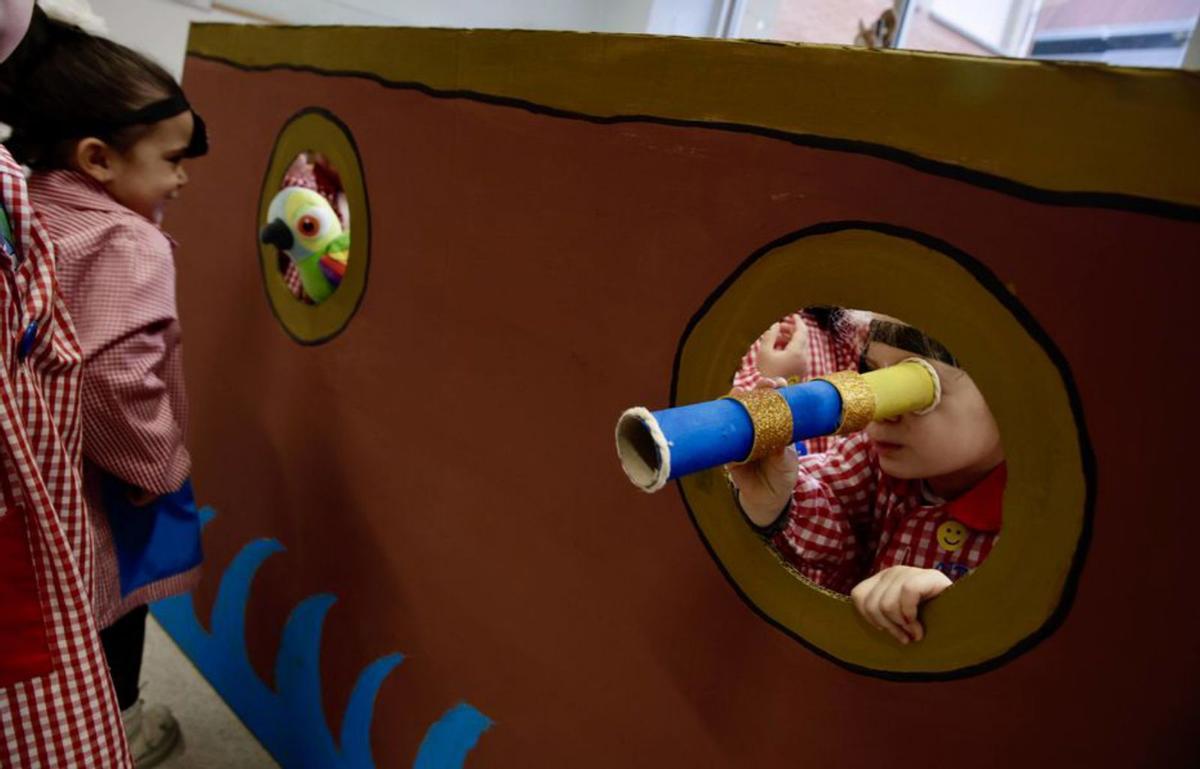 Los escolinos de 4 años enseñen los loros de cartón. Pela izquierda, Dafne Ros, Paula Con, Rocío Fidalgo, Enol Menéndez y Enzo Fernández. Detrás, Mía González y, delantre, Lucía Carriedo. A la derecha, la profesora Marisol Pérez enseña lo que’l Pirata Mala Pata trai cada selmana, xunto a les escolines Inés Vega y Lara Vallina. | JUAN PLAZA