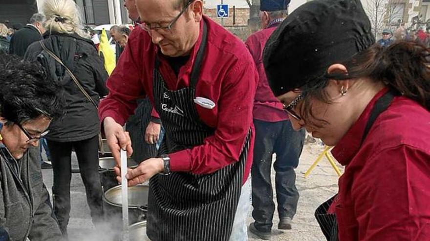 Els cuiners servint les racions d&#039;escudella, ahir al migdia