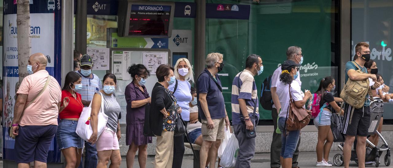 Ciudadanos con mascarilla en una parada de autobús en las Avenidas, en Palma