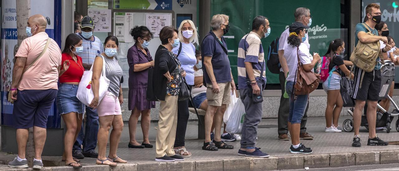 Ciudadanos con mascarilla en una parada de autobús en las Avenidas, en Palma