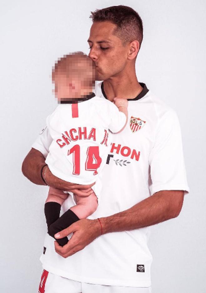 Chicharito y su bebé posando con la camiseta del Sevilla.