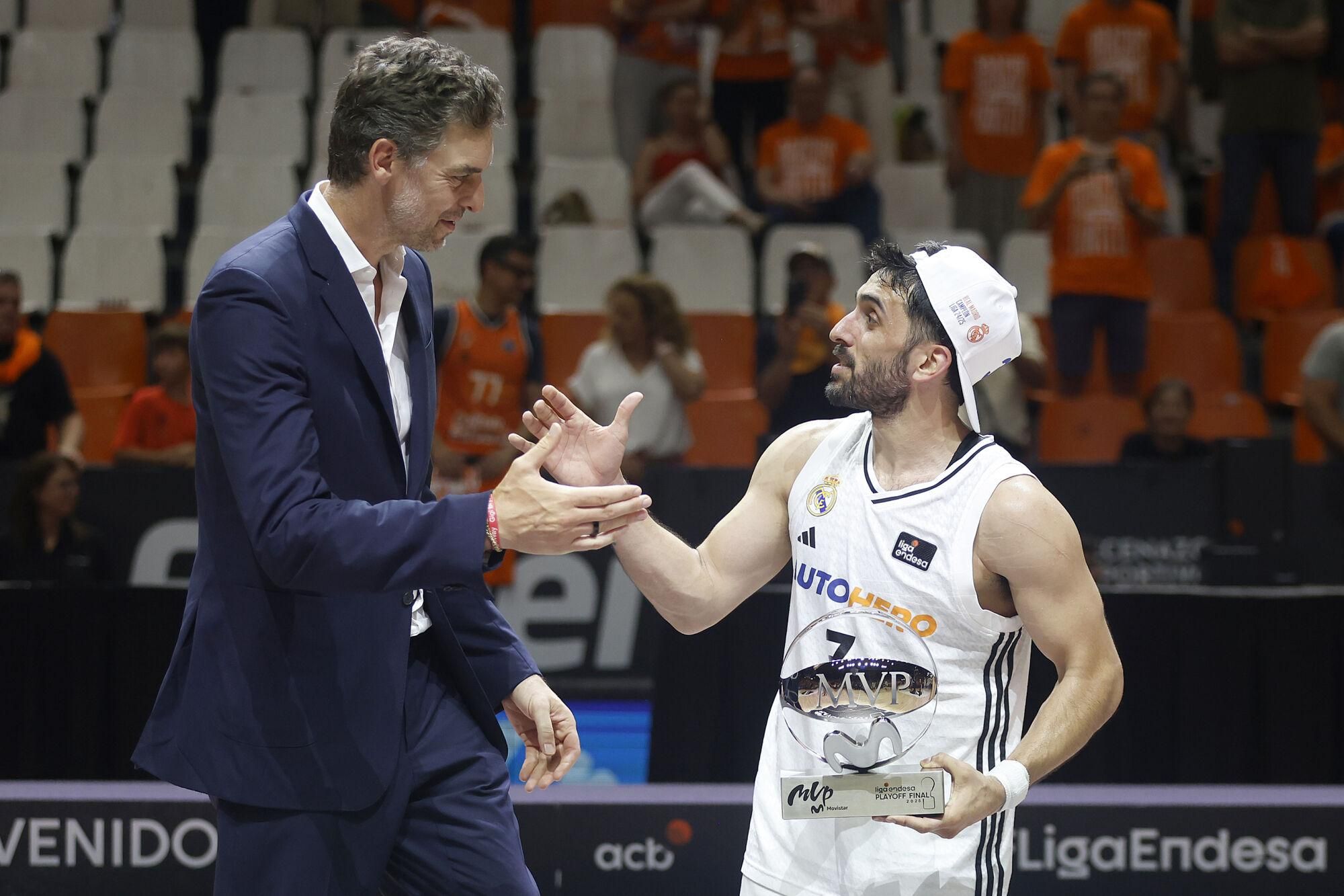 VALENCIA, 25/06/2025.- El base del Real Madrid Facondo Campazzo (d) es felicitado por Pau Gasol tras ser elegido MVP de la final, al término del tercer partido de la final de la Liga Endesa que Valencia Basket y Real Madrid han disputado hoy miércoles en el pabellón de la Fuente San Luis. EFE/Miguel Ángel Polo