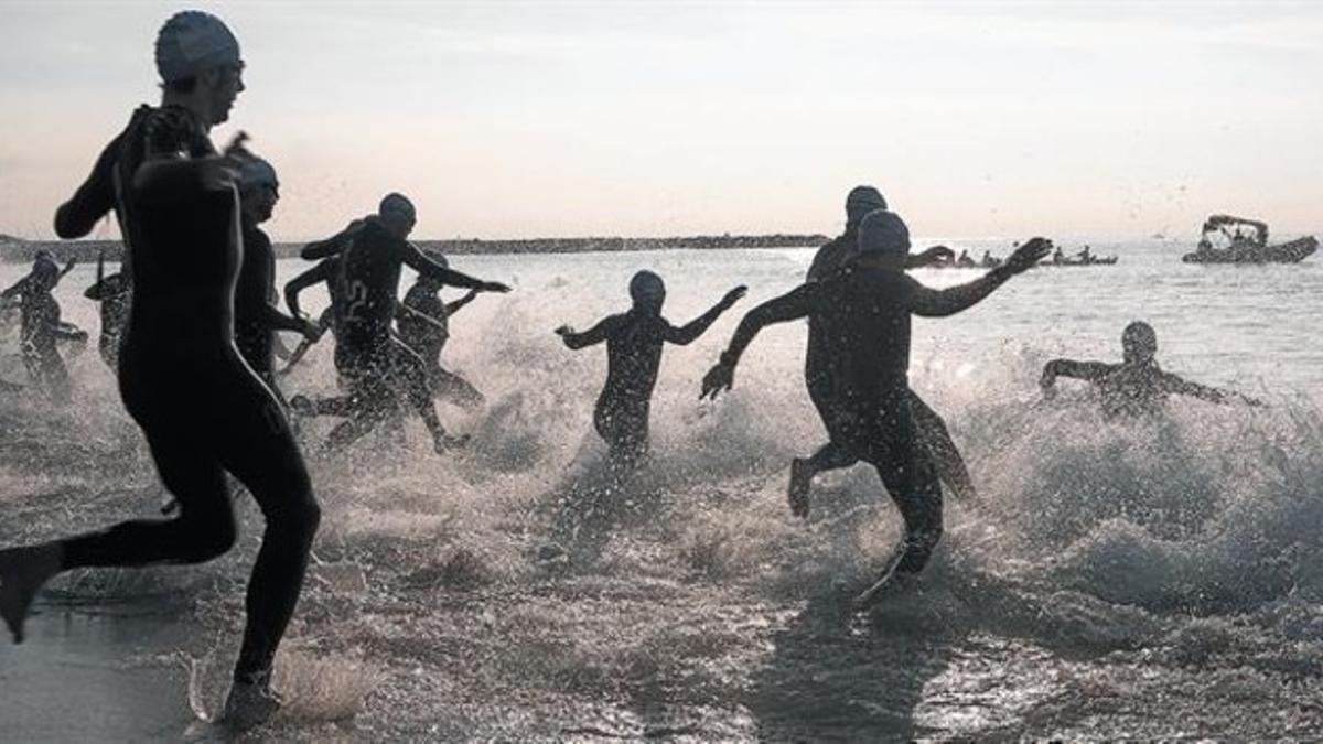 Al agua 8Los triatletas se lanzan al mar, con los trajes de neopreno, ayer por la mañana en la playa de Barcelona.