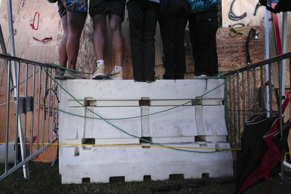 Protesters watch police activity while standing on a construction barrier on the UCLA campus Wednesday, May 1, 2024, in Los Angeles. (AP Photo/Jae C. Hong) Associated Press/LaPresse / EDITORIAL USE ONLY/ONLY ITALY AND SPAIN