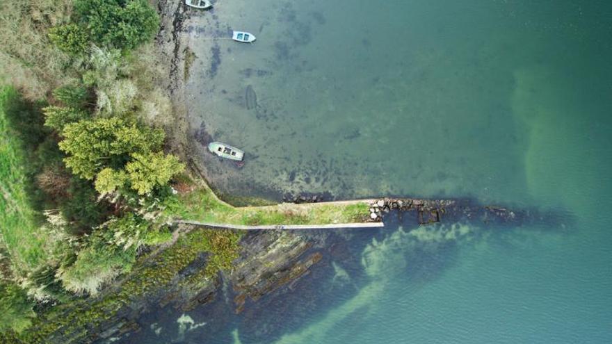 Muelle de Area Basta (Ribeira). Este pequeño muelle se edificó aprovechando una plataforma de rocas. Es posible que en el extremo que termina en el agua se instalasen pequeñas infraestructuras de producción acuícola: el dique protege, pero sirve también para descarga y transporte. | DAVID GARCÍA-LOUZAO