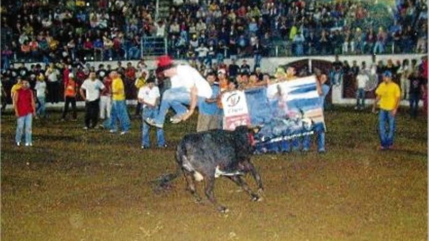 Un noi amb barretina salta per damunt del toro, en un dels darrers correbous.