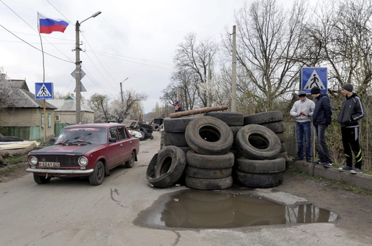 Un cotxe passa al costat d’un control de manifestants prorussos a Donetsk (Ucraïna).