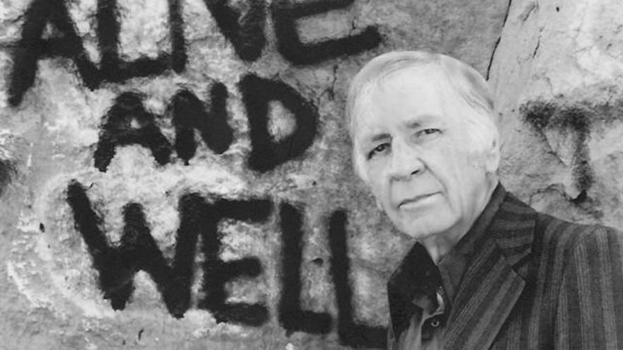 Jim Thompson a finales de los 70, delante de un irónico graffiti sobre su propia existencia.