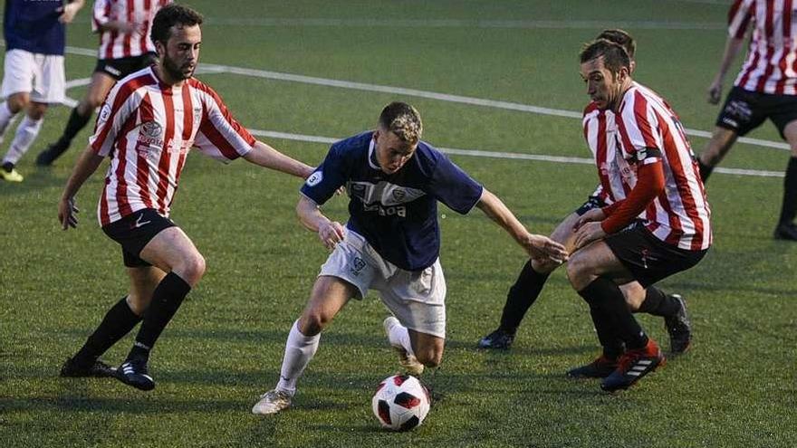 César García, rodeado de jugadores del Siero, en el partido de ayer en El Bayu.