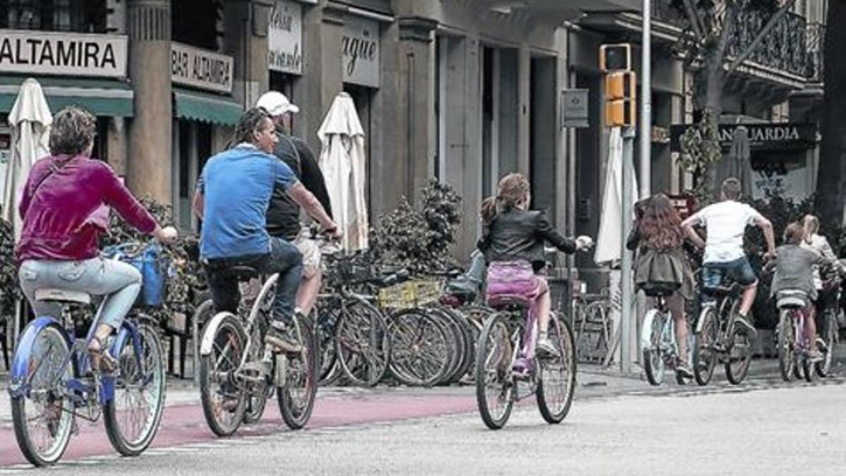 Varios menores circulan sin casco por el carril bici de la calle de Girona, ayer.