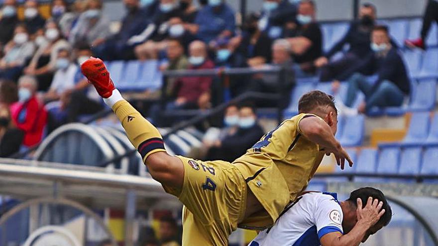 Carlos Giménez le gana el pulso a Chuli en un balón dividido. | HÉCTOR FUENTES